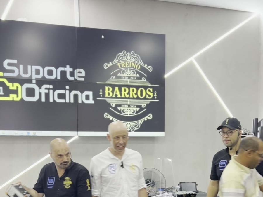 Alunos e instrutores na entrega de certificados, em frente ao painel Suporte a Oficina e Treino Barros