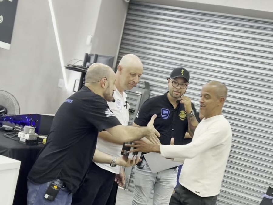 Entrega do certificado do curso com aperto de mão entre instrutor e aluno