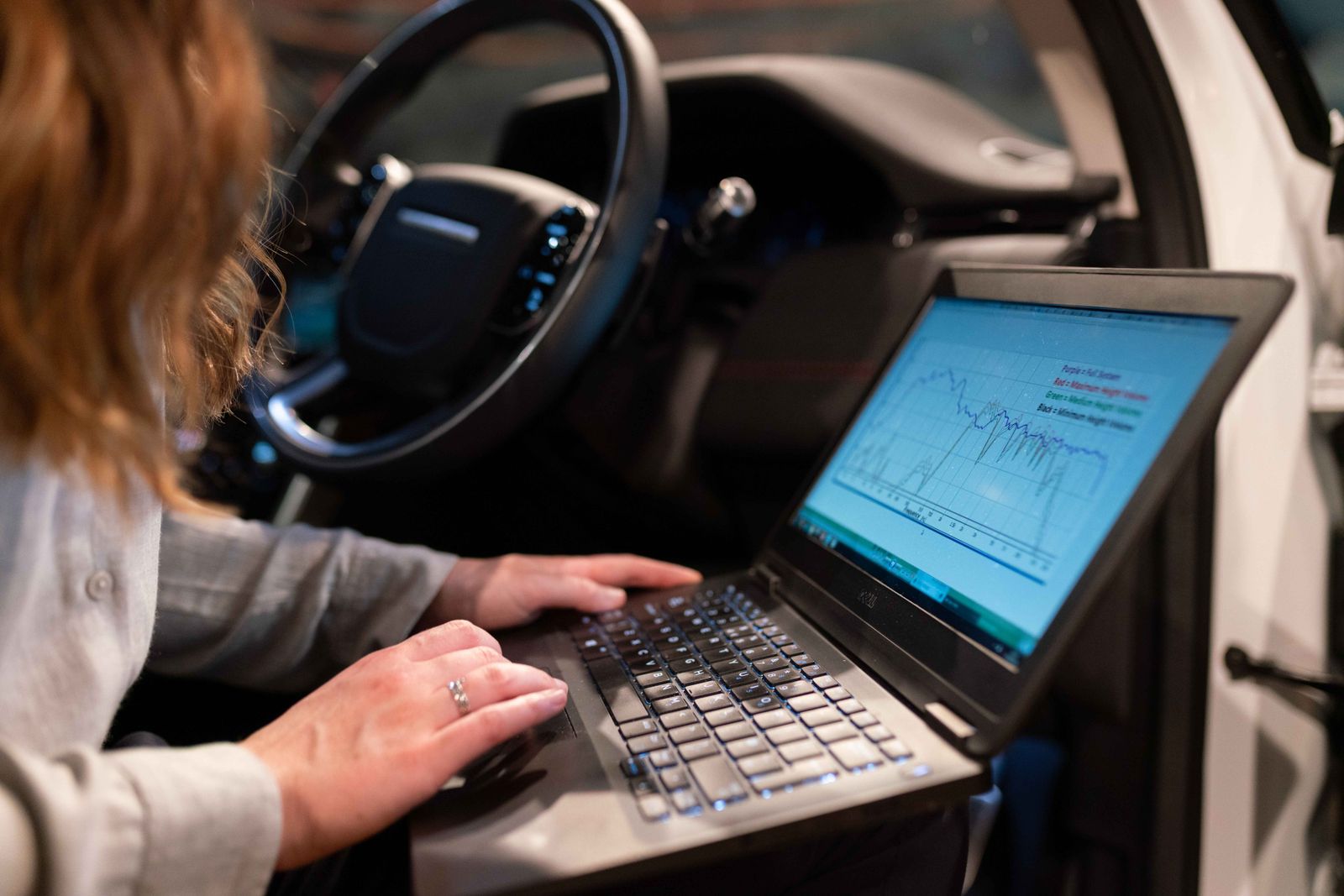 Laptop connected to a vehicle during electronic diagnostics and programming